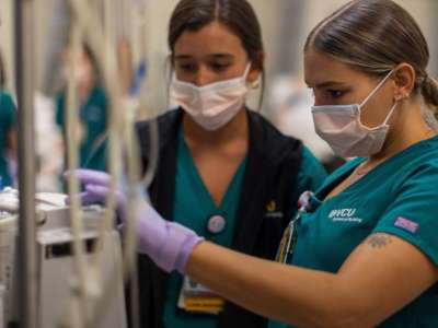 two nursing students work together on operating a clinical device