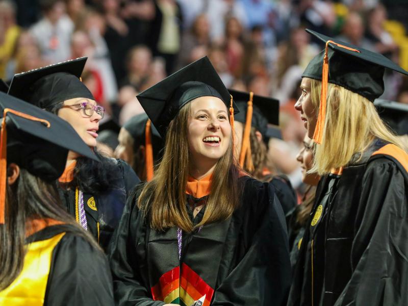 v.c.u. nursing graduates stand in a crowd and smile during commencement