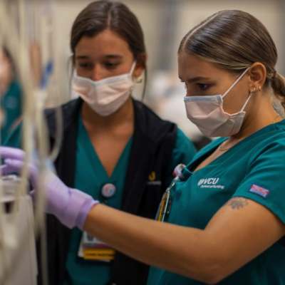 two nursing students work together in a clinical learning center simulation