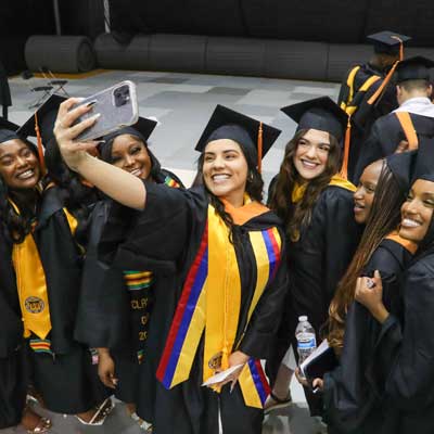 a happy group of v.c.u. school of nursing graduates take selfies at their commencement ceremony