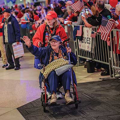 edna livengood being pushed in a wheelchair at a patriotic parade honoring heroes