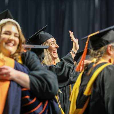 new v.c.u. school of nursing students waving and hugging each other at their commencement ceremony