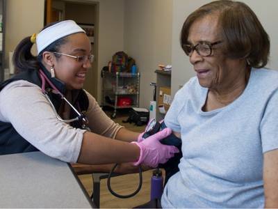 a nursing student performs a blood pressure check on a community clinic participant