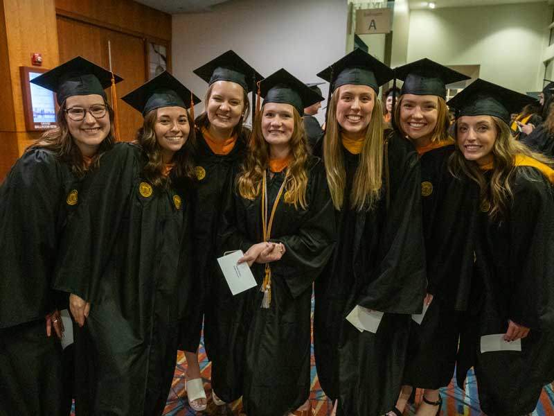a group of v.c.u. school of nursing students dressed in regalia and celebrating at their commencement ceremony