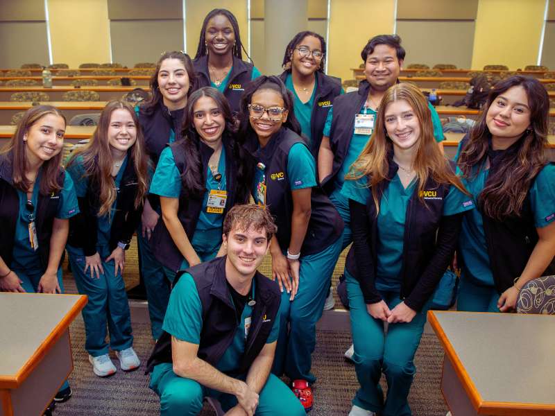 a group of undergraduate students in VCU School of Nursing vests smile