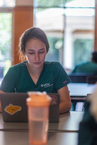 a v.c.u. nursing student works on a laptop in the student lounge