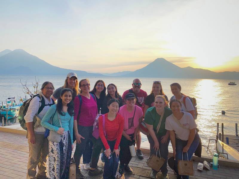 a group of v.c.u. nursing students and two faculty members pose in front of a Guatemalan sunset