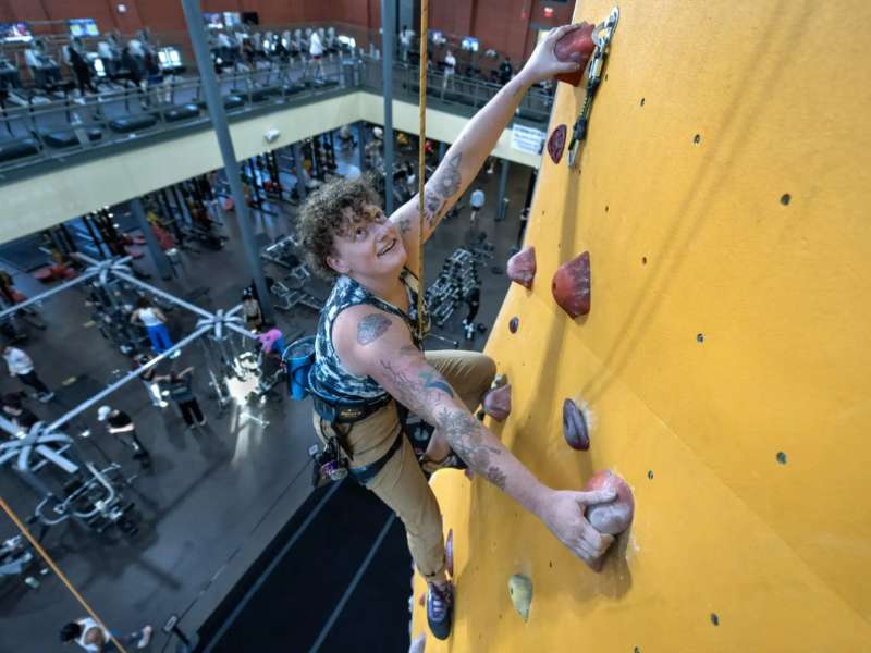 austin haley climbing a rock wall at the v.c.u. cary street gym