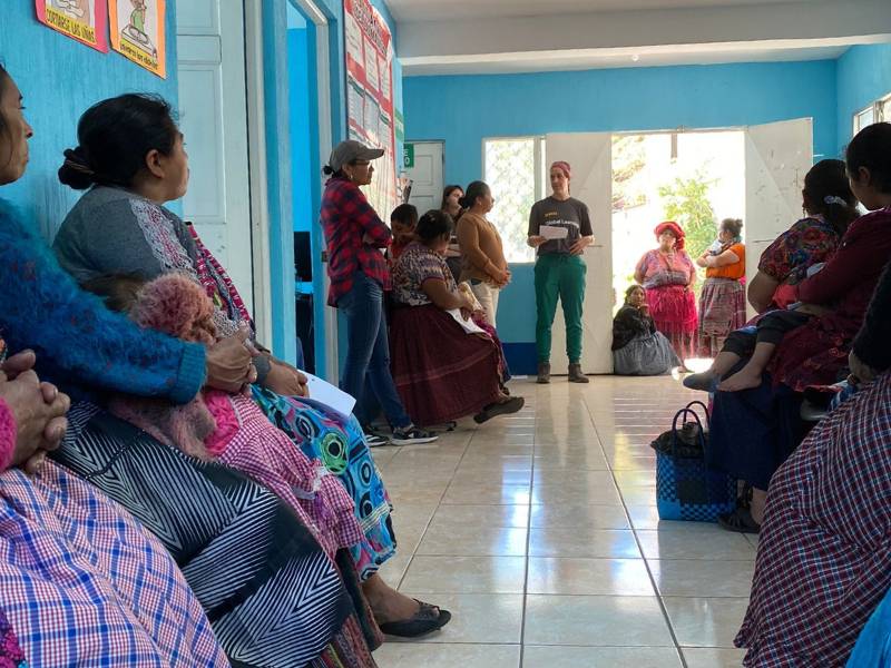 a v.c.u. nursing student gives a presentation to a crowded room of guatemalan women in a health clinic