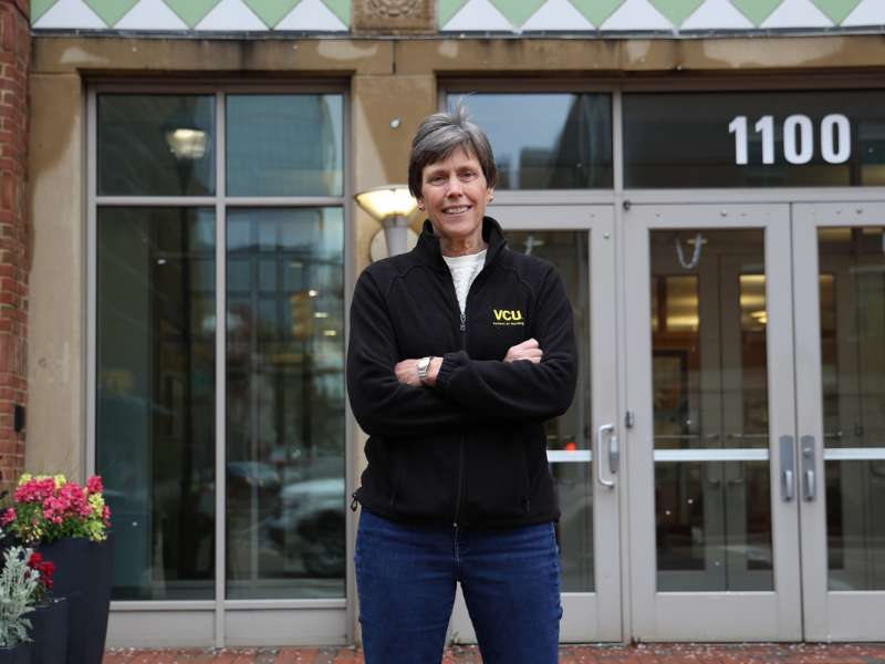 jean giddens stands in front of the school in v.c.u. nursing gear