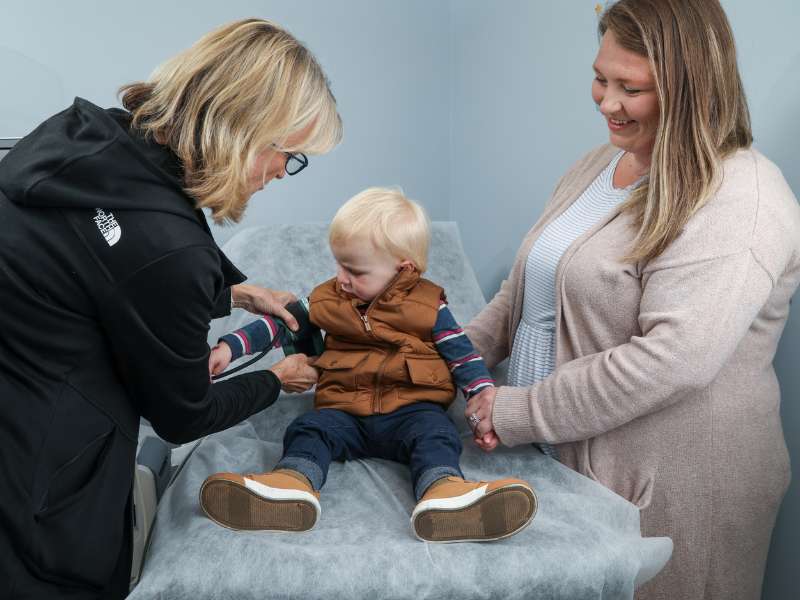 a clinician measures the blood pressure of a toddler while the mother looks on