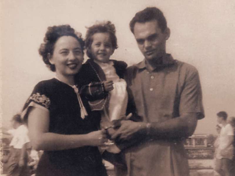 an old black and white photograph of a young woman and man holding a small child