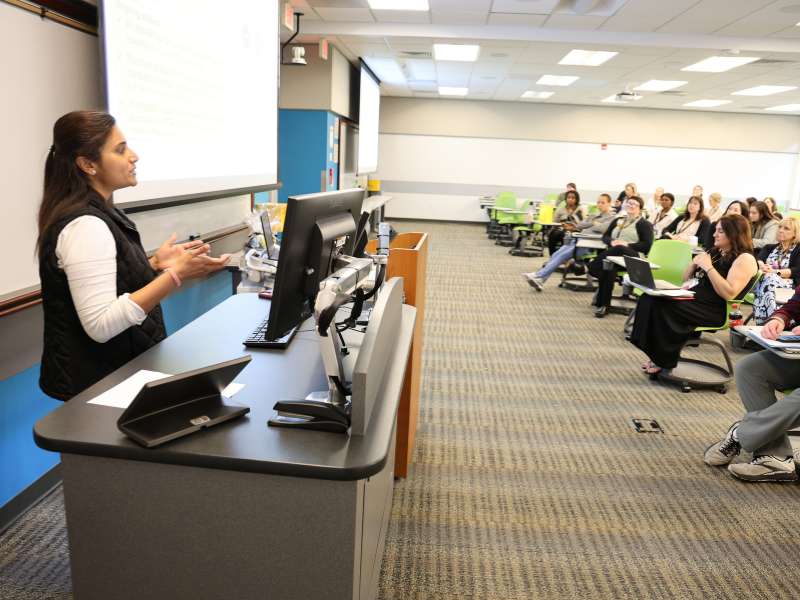 Lathika Mohanraj, Ph.D., gives a talk from a classroom podium