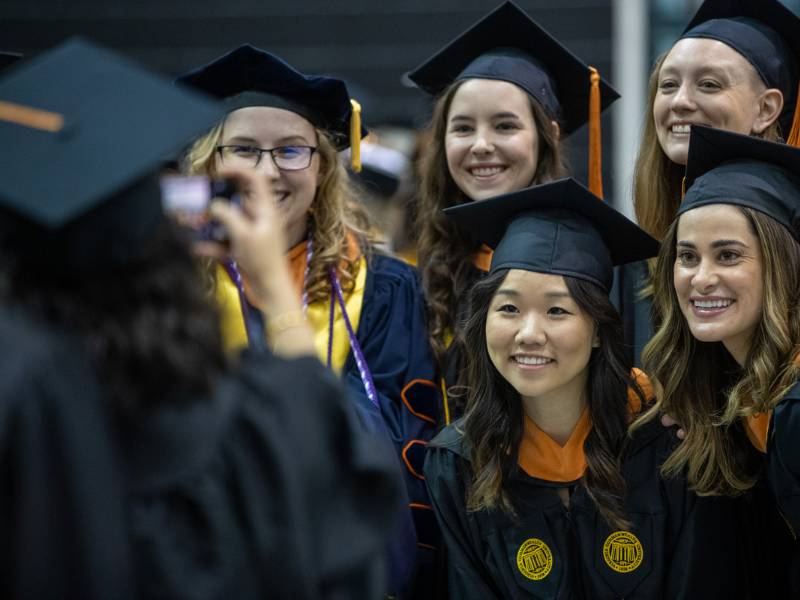 a group of nursing students get together for a group photo taken by another student