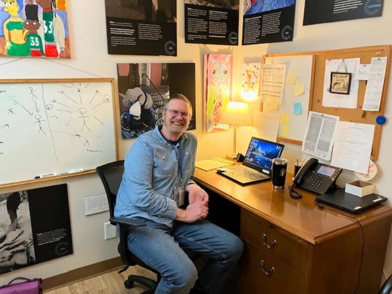 michael sullivan sits as a desk with an open laptop