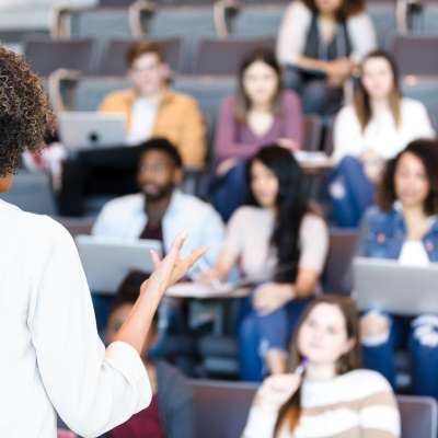 a lecturer addresses an auditorium of people