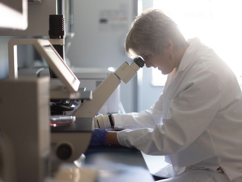 A nurse scientist uses a microscope