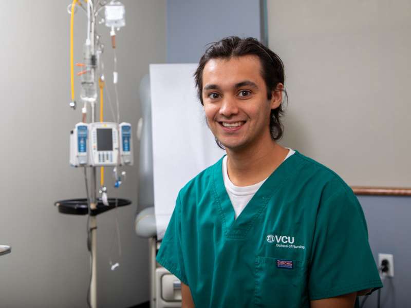 a v.c.u. nursing student poses in front of an exam room table