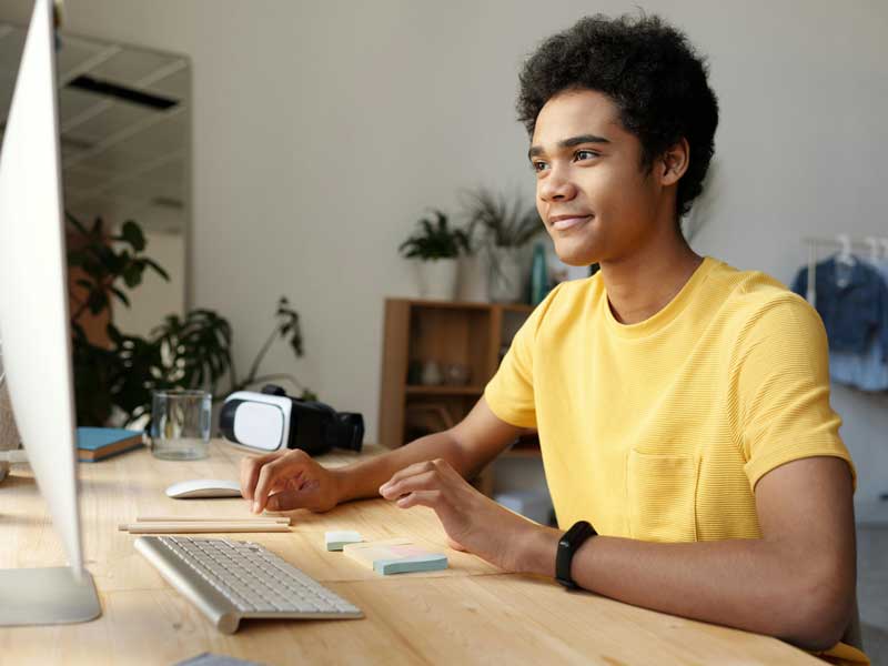a person seated at a desk using a desktop computer in an office setting